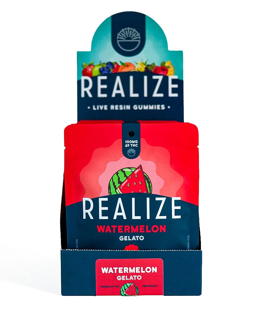 Wholesale display box featuring Realize Live Resin Gummies in Watermelon Gelato flavor. The display contains bright red 100mg Δ9 THC gummy pouches with a watermelon illustration and Realize branding, presented in a navy countertop display with a matching Watermelon Gelato product label.